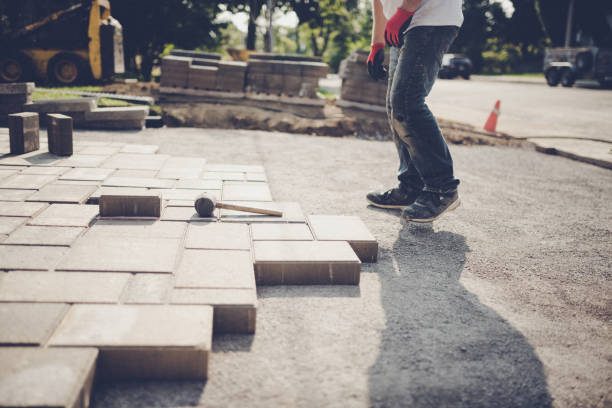 Young man installing paving stones for a new driveway