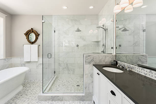Beautiful master bathroom with shower, bathtub, and sink,  with high end furnishings, lights on