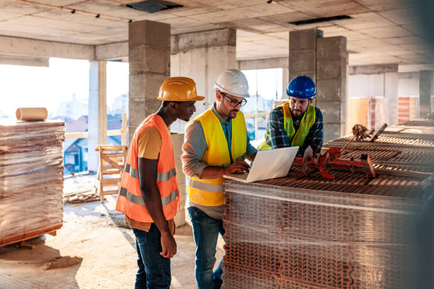 Engineer, architect and business man working on the engineering project at construction site. House building concept. Photo of young male architect engineer using laptop computer.